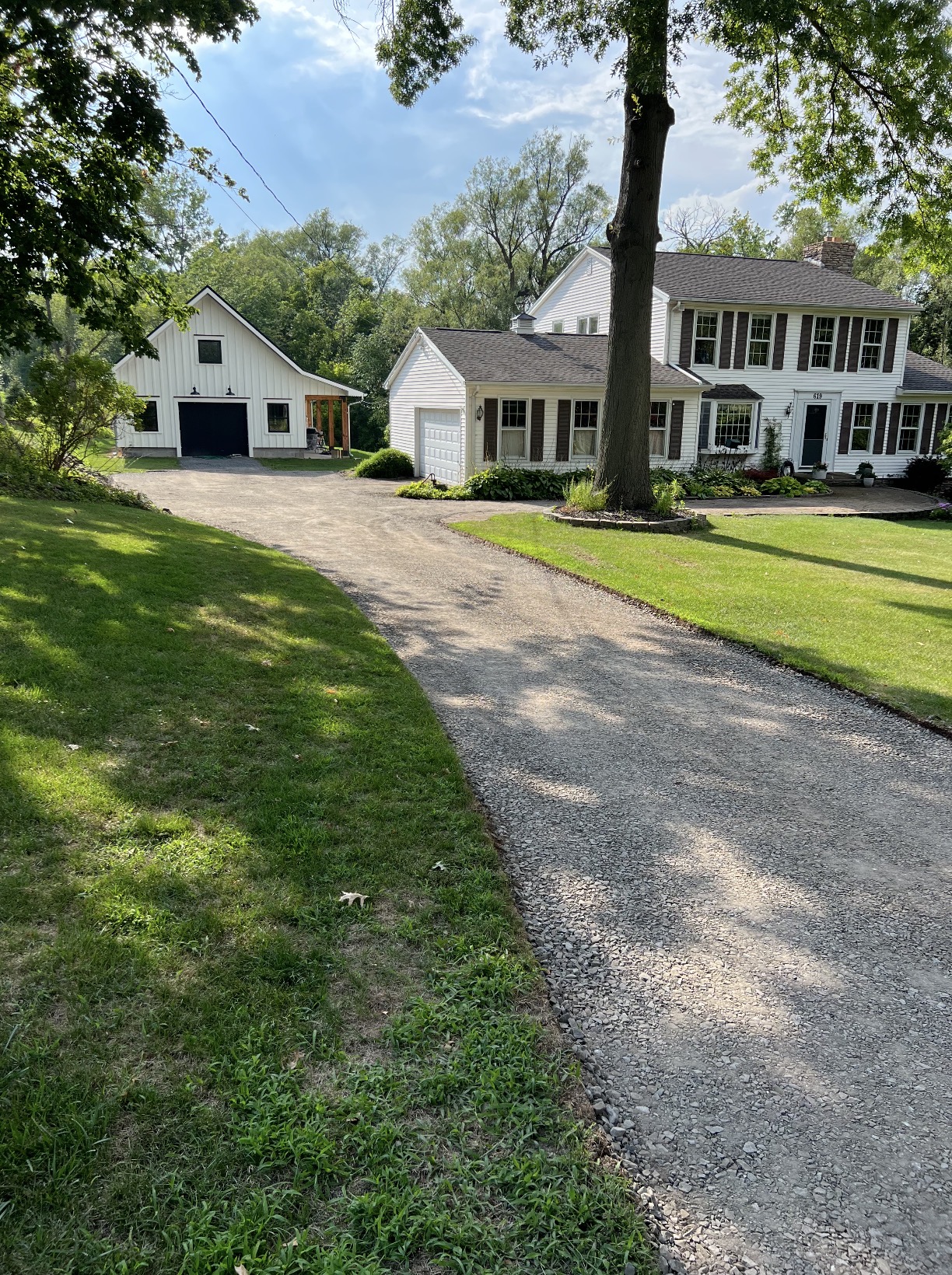 Wide stone driveway prepared between a home and detached garage