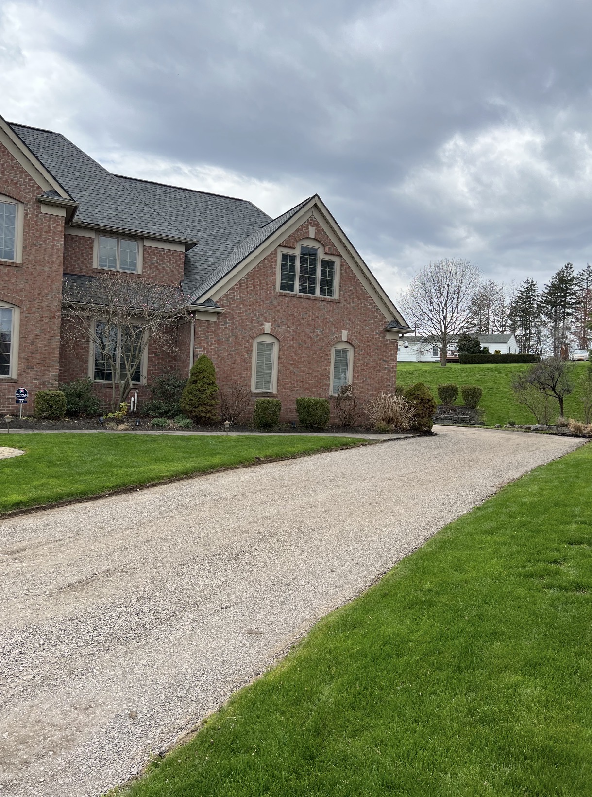 Freshly graded stone driveway at a brick residence