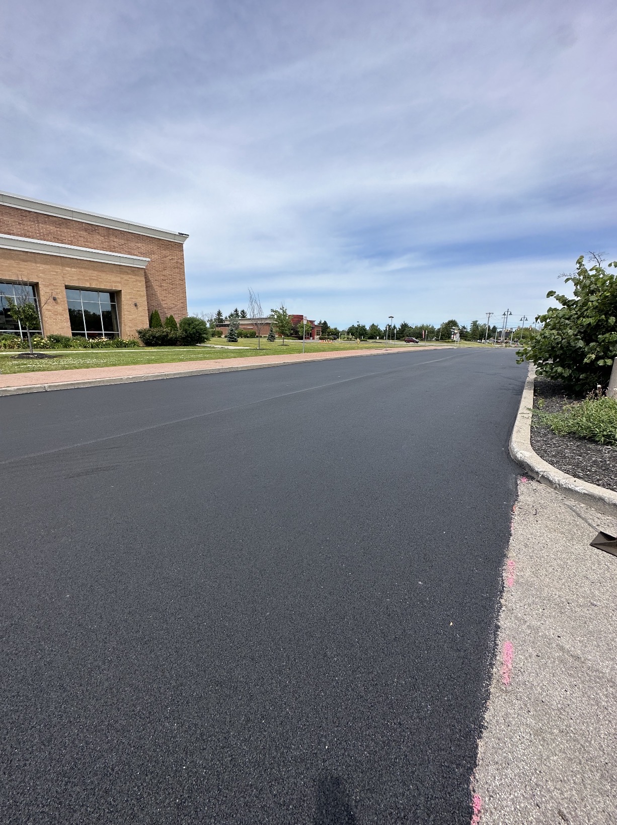New asphalt drive along a commercial brick building