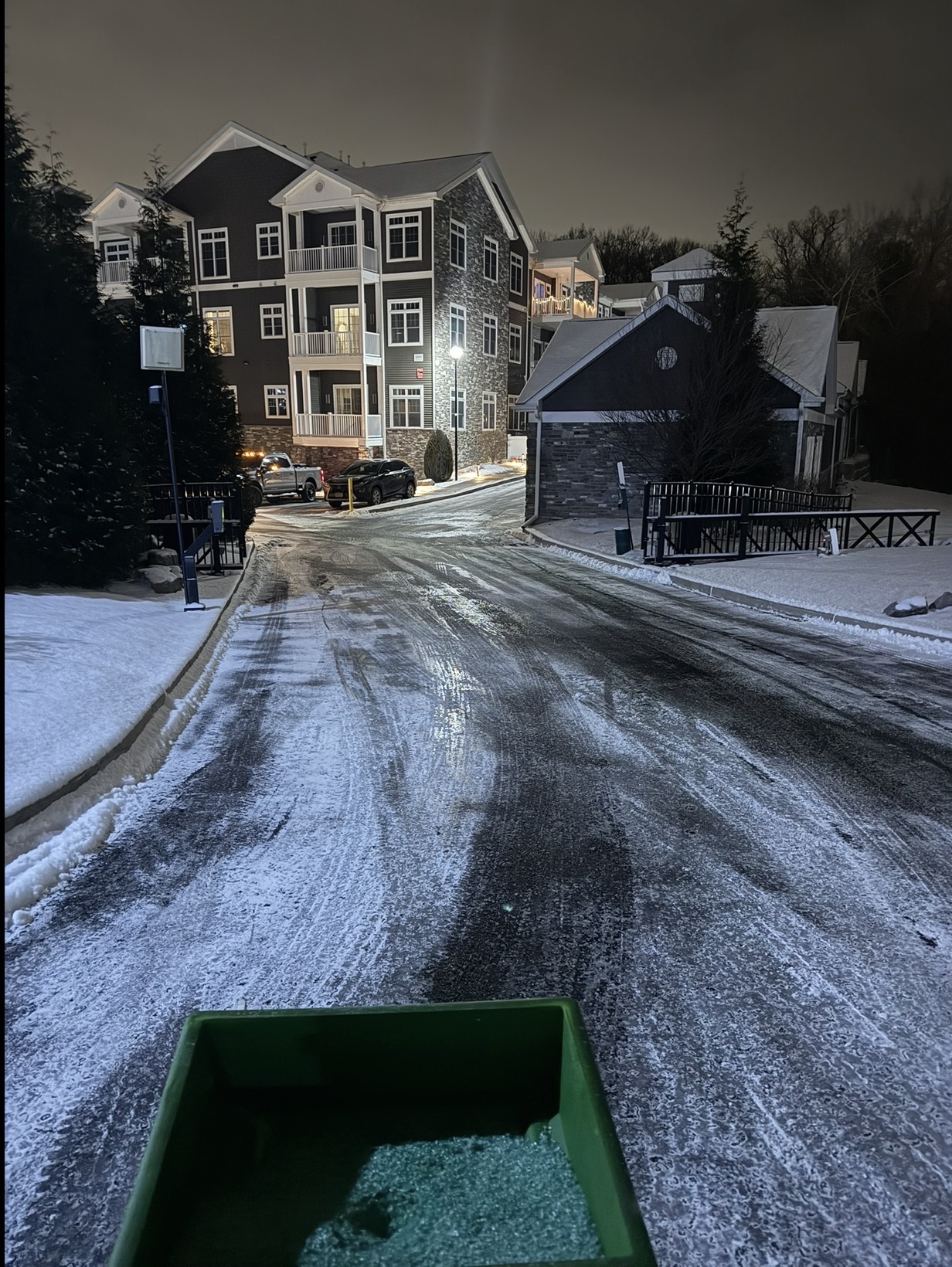 Salted and plowed apartment complex roadway at night