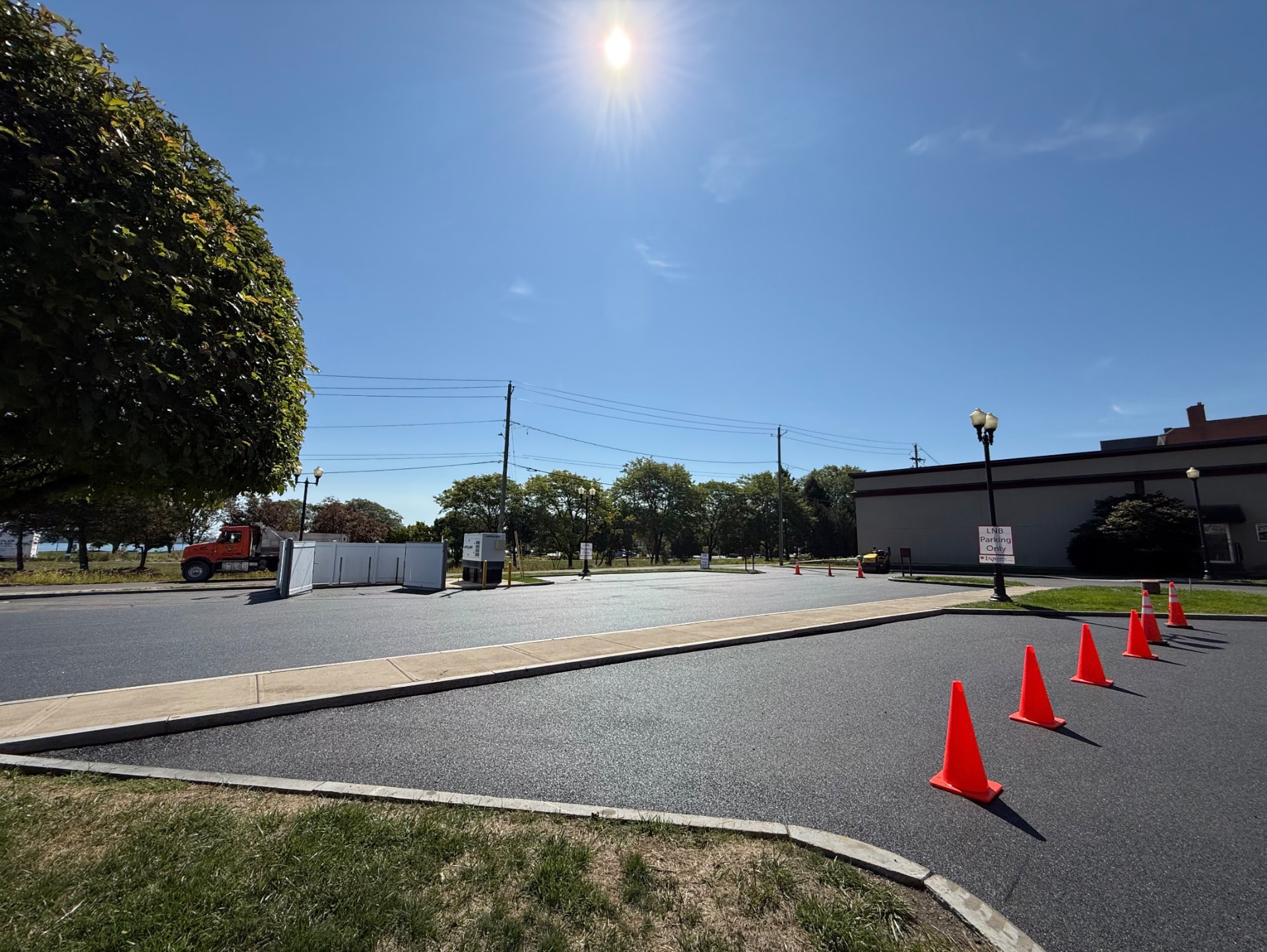 New asphalt parking lot with cones and curbing at a bank